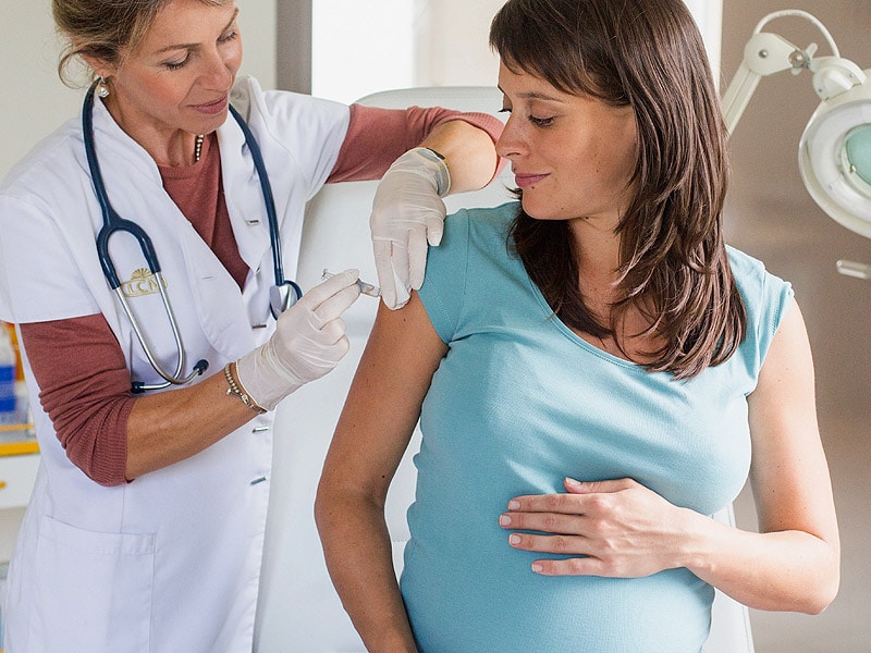 enfermera vacunando a una mujer embarazada